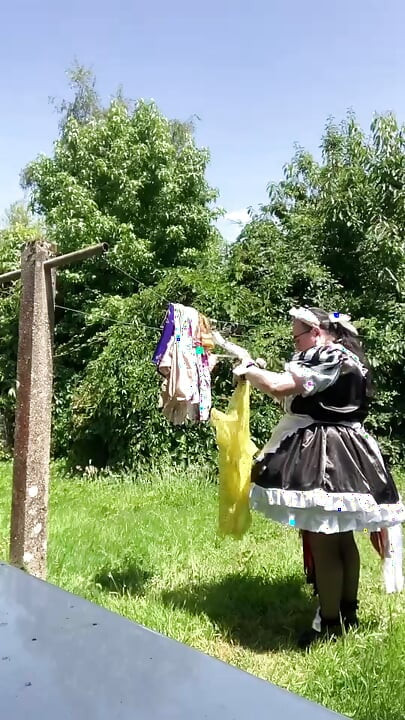 In a black and white maid outfit to hang out the laundry.