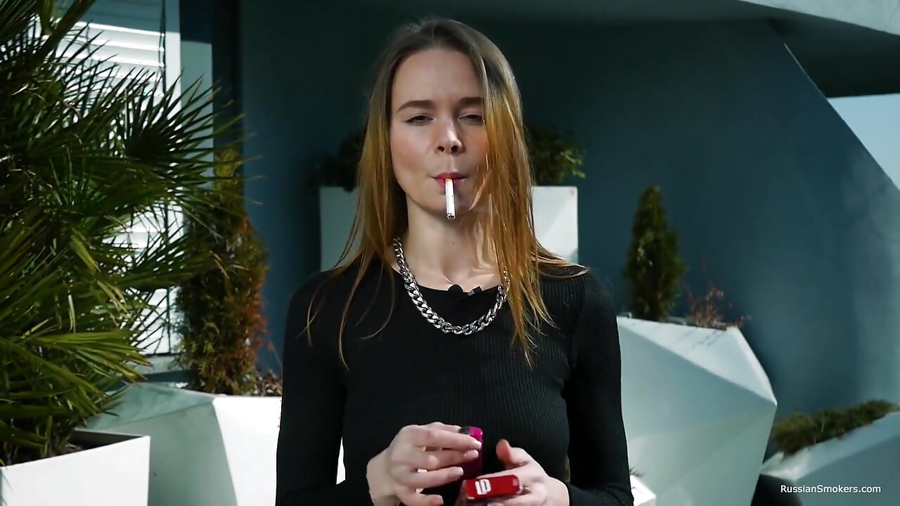 年轻的俄罗斯女孩在海边抽烟