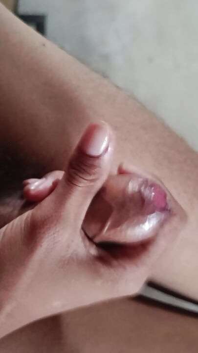 The boy is shaking his penis in his hand and ejaculating.