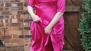 Hot sissy crossdresser na zewnątrz w pełnej długości gorącej różowej satynie