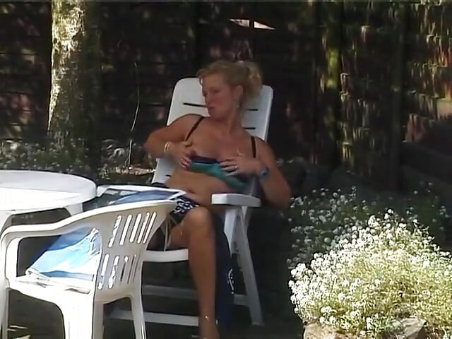 Blonda matură își freacă pizda în aer liber