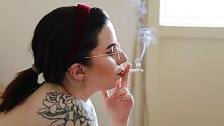 La modella tatuata nuda fuma una sigaretta sul cammello s100