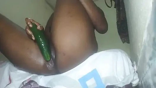 Black desi girl with an amazing body is putting a large cucumber into her pussy