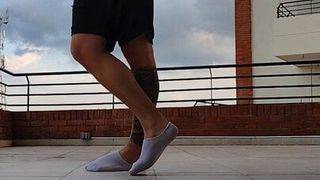 Un latino montre ses chaussettes en plein air (gros pieds)