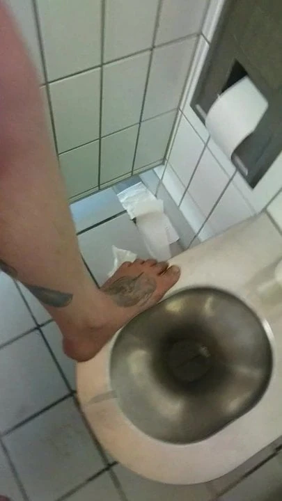 Barefoot on a filthy public toilet and tapping some piss