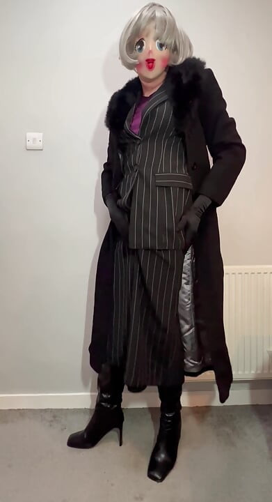 Crossdressing mietje gekleed in haar nieuwe rokpak en lange jas