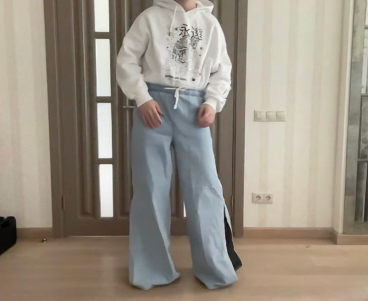 Sissy w szerokich nogawkach palazzo bootcut rozkloszowanych dżinsach i białej bluzie z kapturem na wysokich obcasach gotowa na wieczorny taniec i spermę