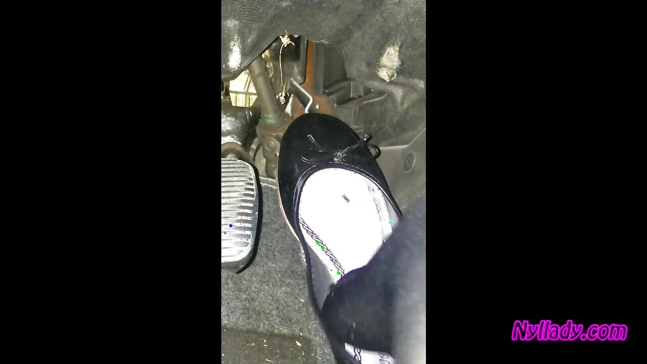 Nyllady conduciendo y revisando su Bravo con botas de tacón alto y zapatillas de ballet negro