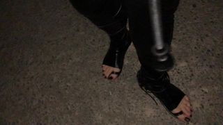 На улице в костюме в латексе с черными пальцами ног, с насосом и с сосками