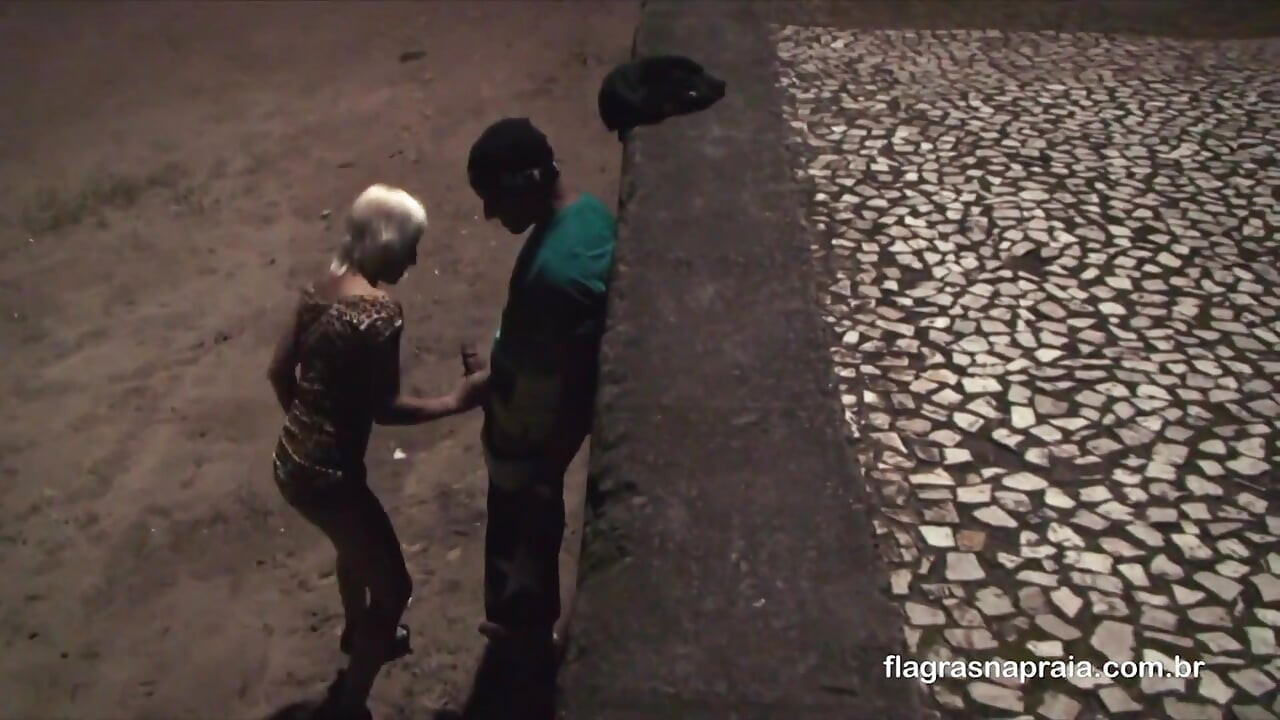Pareja follando por la noche en la arena de la playa