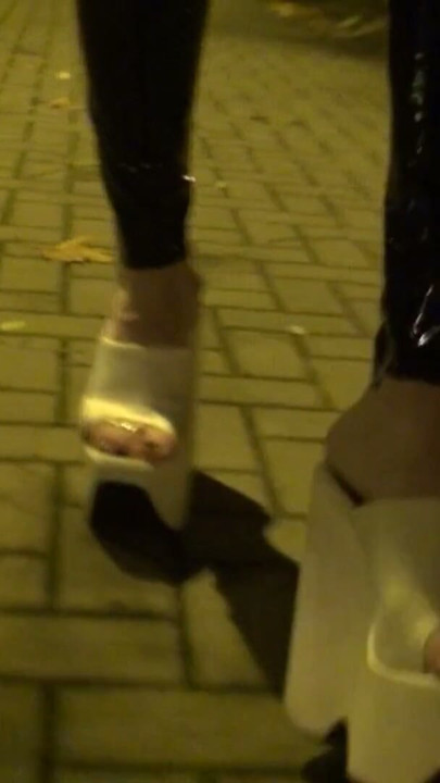 Crossdresser berjalan di jalan dengan legging lateks dan wedges putih yang sangat tinggi | Klip 1