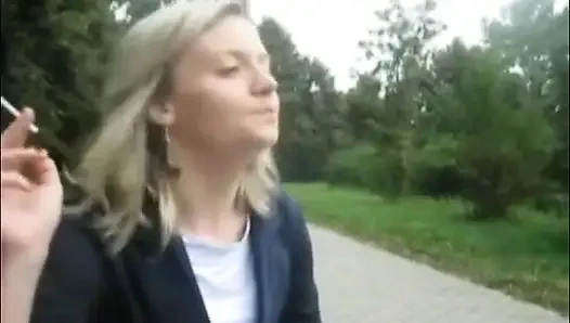 Blonde schönheit, die draußen eine zigarette raucht