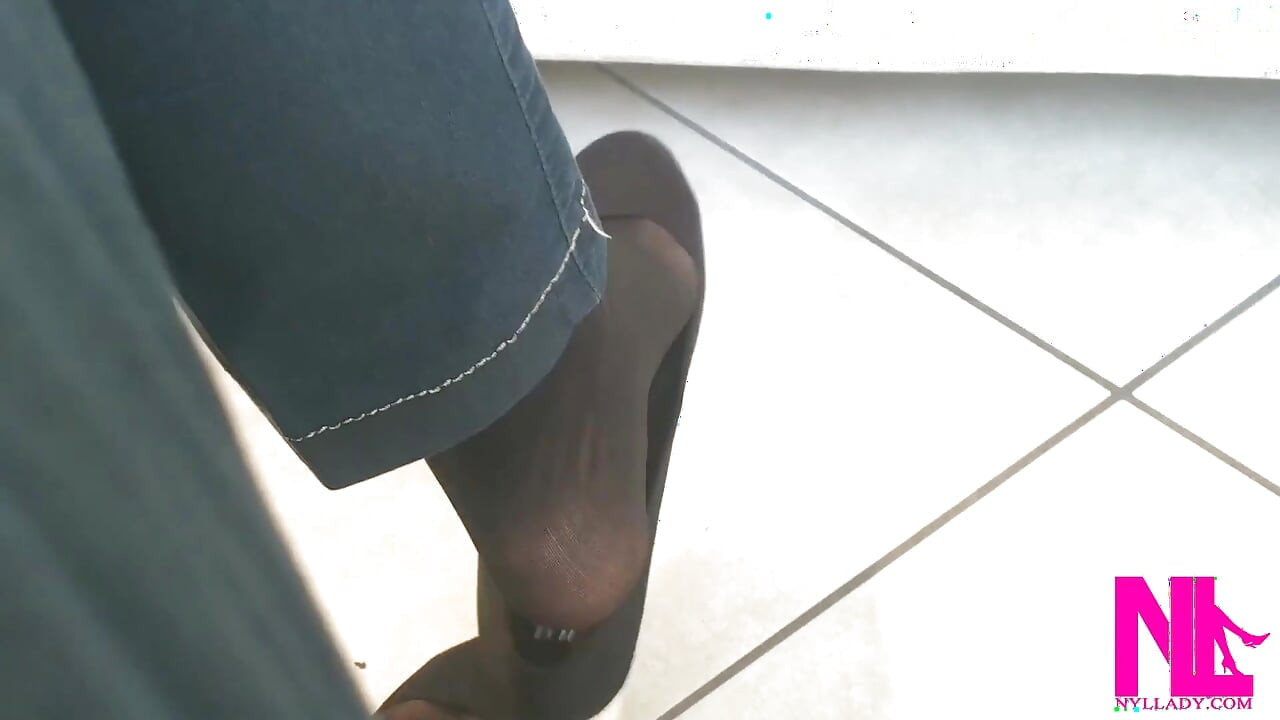黒いフラットシューズと黒いナイロンソックスでぶら下がっている