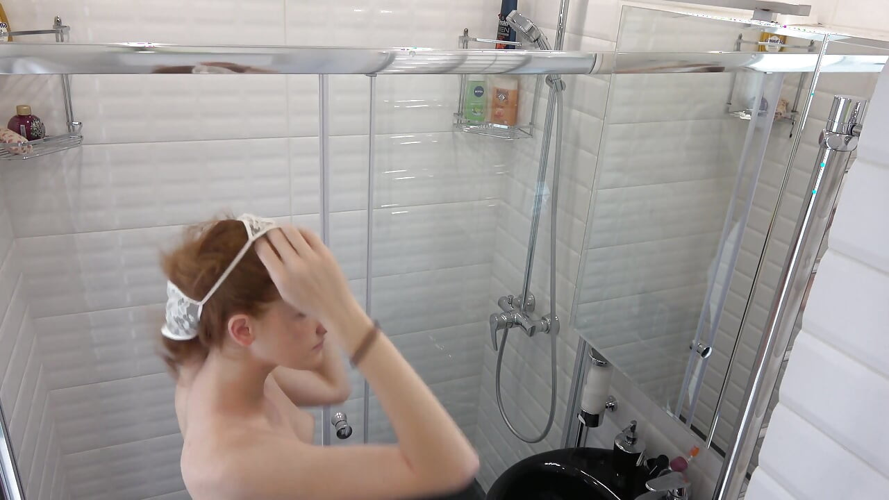 Rødhåret teenager med små bryster i brusebadet