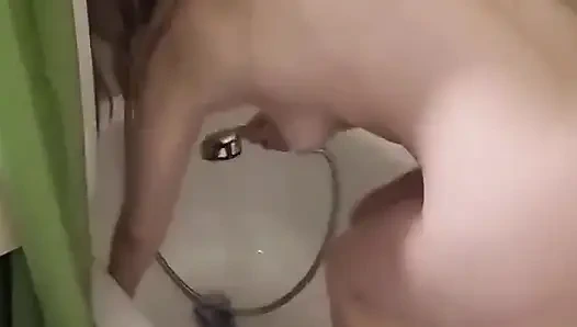 Gadis pucat pirang muda, membersihkan bak mandinya sepenuhnya telanjang