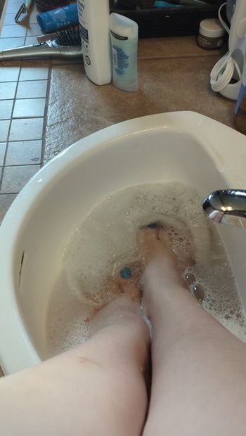 Feet getting soapy and wet.