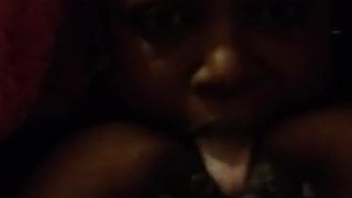 Busty Ebony sucking both her nipples in bed