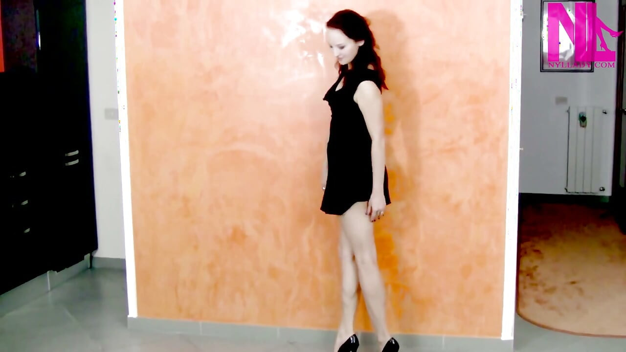 Modelando e esticando minhas pernas nuas em salto alto patente preto