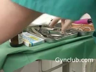 Jururawat melancap di atas kerusi ginekologi dalam sarung tangan lateks