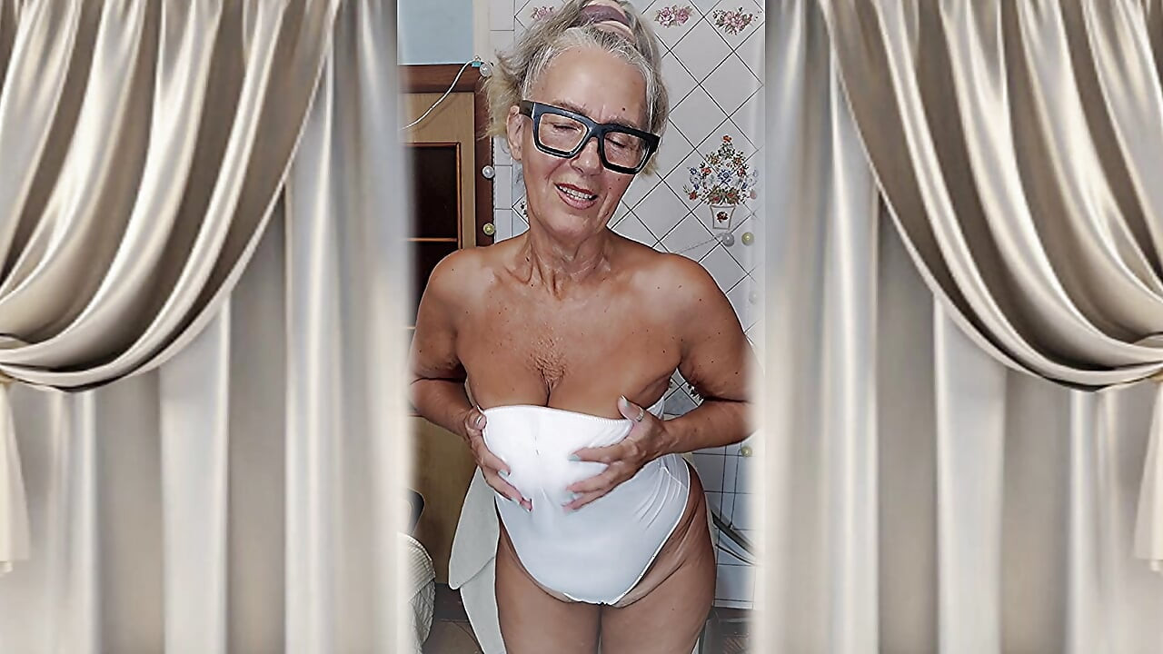 Hot housewife Lukerya flirts in her white lingerie at home in the kitchen.