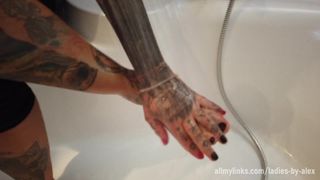 Une femme blonde tatouée se lave les pieds