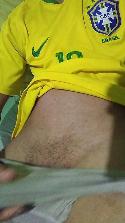 Young Brazilian masturbates big thick cock taking off his clothes wearing the Brazilian national team soccer uniform