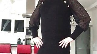 Nicki-Crossdress en un mini vestido negro, pantimedias negras y tacones altos