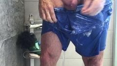 Seifige Dusche in dünnen blauen Shorts