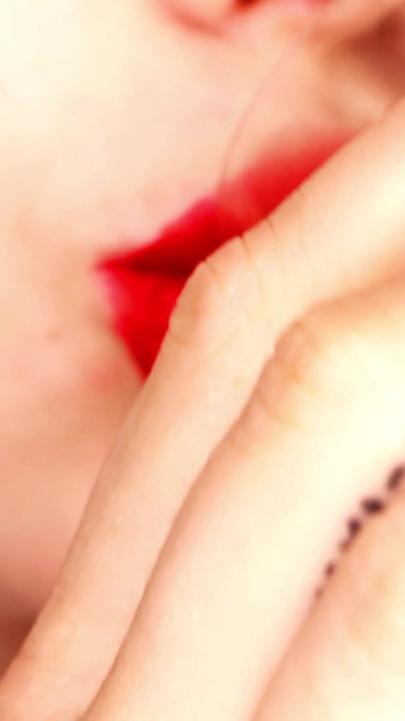 4k Aplicando lápiz labial rojo y fumando prostituta sobre fondo negro