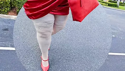 Beautiful woman walking outdoors in public parking lot showing off for strangers