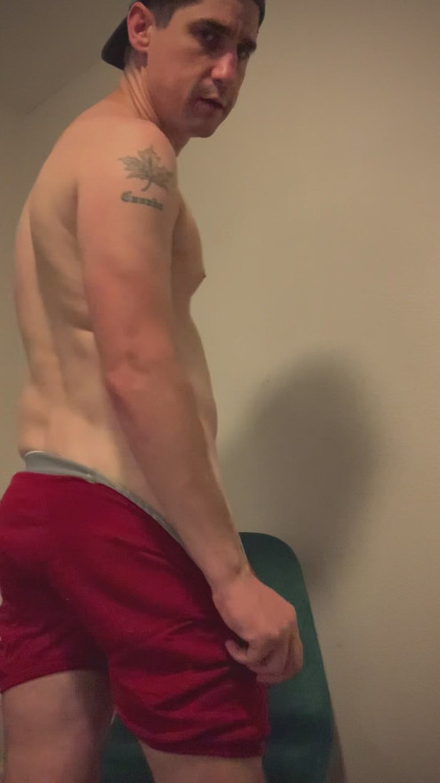 Baseball player shows off his sweaty body after he won a game.