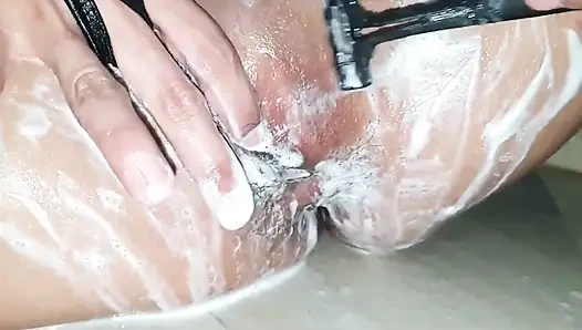 Sevimli kız sevimli amcığını işiyor ve tıraş ediyor.