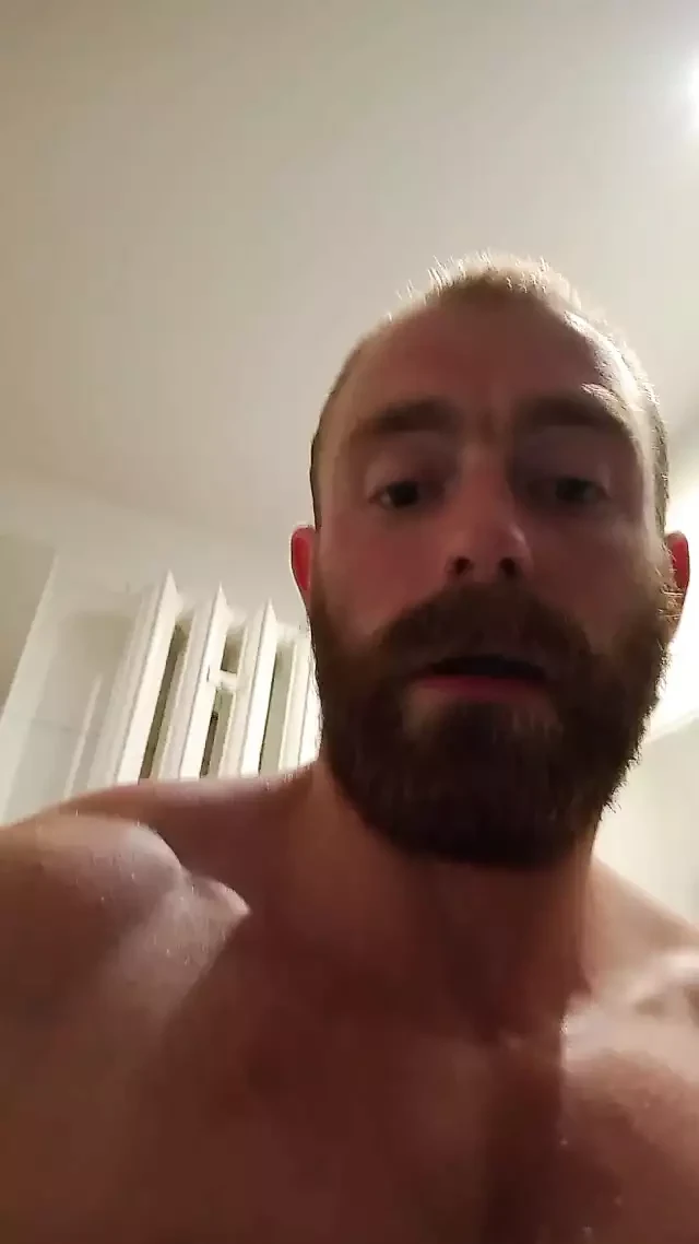 Muscular fitness bodybuilder is cleaning body taking shower and doing muscle worship