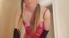 Jess Silk dans une robe en satin rose vif et une nuisette en satin rose vif avec une longue perruque brune