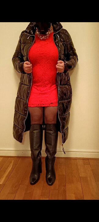 Crossdresser, une trans en manteau en latex et une robe rouge se masturbe.