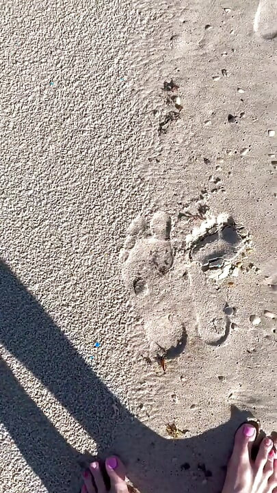 Comparing Size 16 Feet to Sand Prints at the Beach