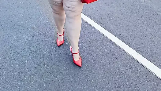 Beautiful woman walking outdoors in public parking lot showing off for strangers