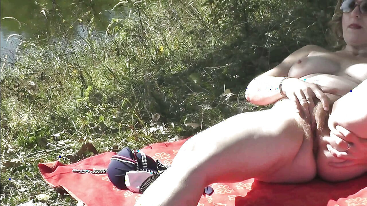 Sexy mature milf sunbathes naked on shore river fingering masturbating hairy pussy and orgasm. Outdoor Outside Naked public Solo