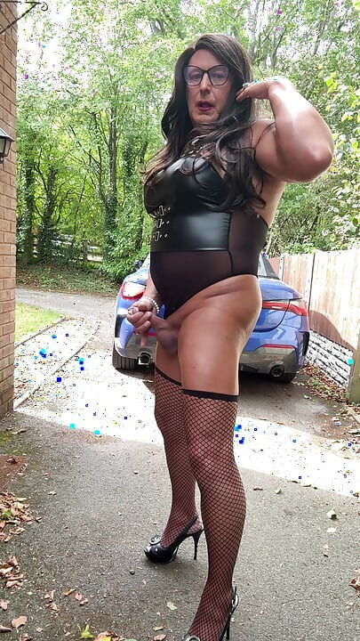 Seksi transvestit kellycd2022 u crnom PVC bodiju i mrežastim čarapama i štiklama