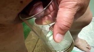 Small Asian dick pees into glass