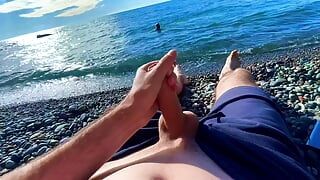 Хлопець дрочить член на нудистському пляжі, а до нього приєднався перехожий