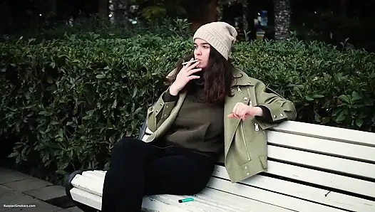 Junge brünette macht einen entspannten spaziergang mit Allwhite 120mm Zigarette