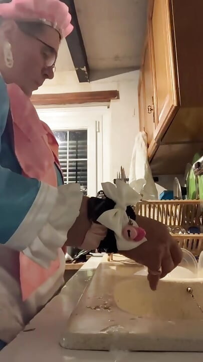 In a blue maid's outfit with pink bows to do the dishes.