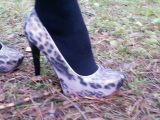 Bayan l leopar topuklu ayakkabılarla yürüyor.