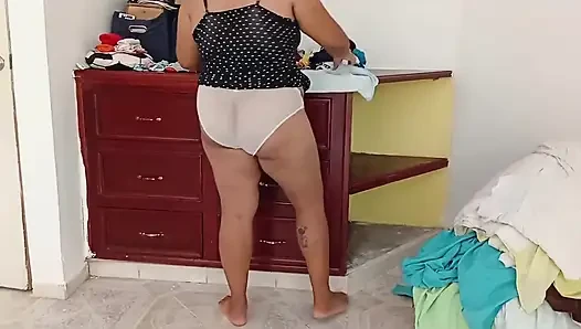 Tombul kız odayı topluyor ve kıyafetlerini katlıyor