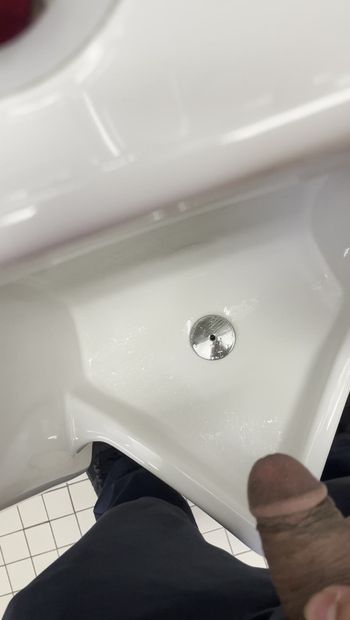 Indischer mann pisst ins öffentliches urinal