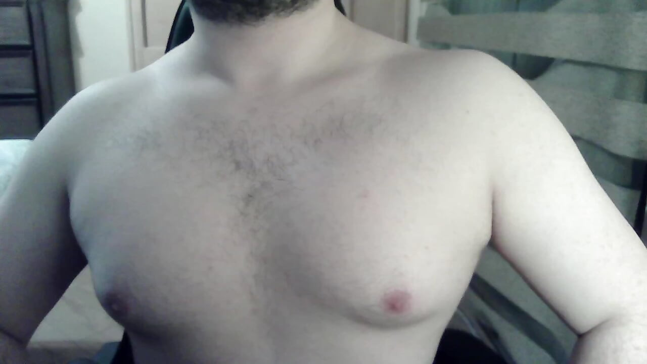 Muscular camboy flexes his muscles and squats