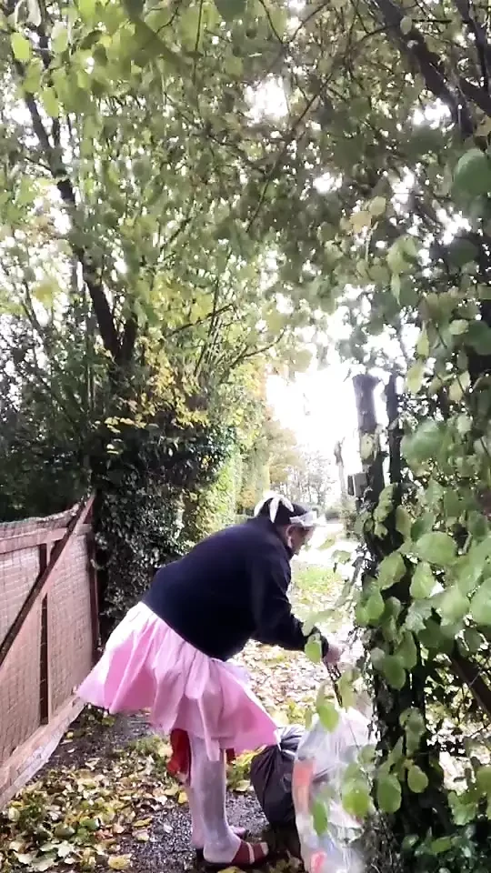 In a pink maid's outfit to go carry the trash can