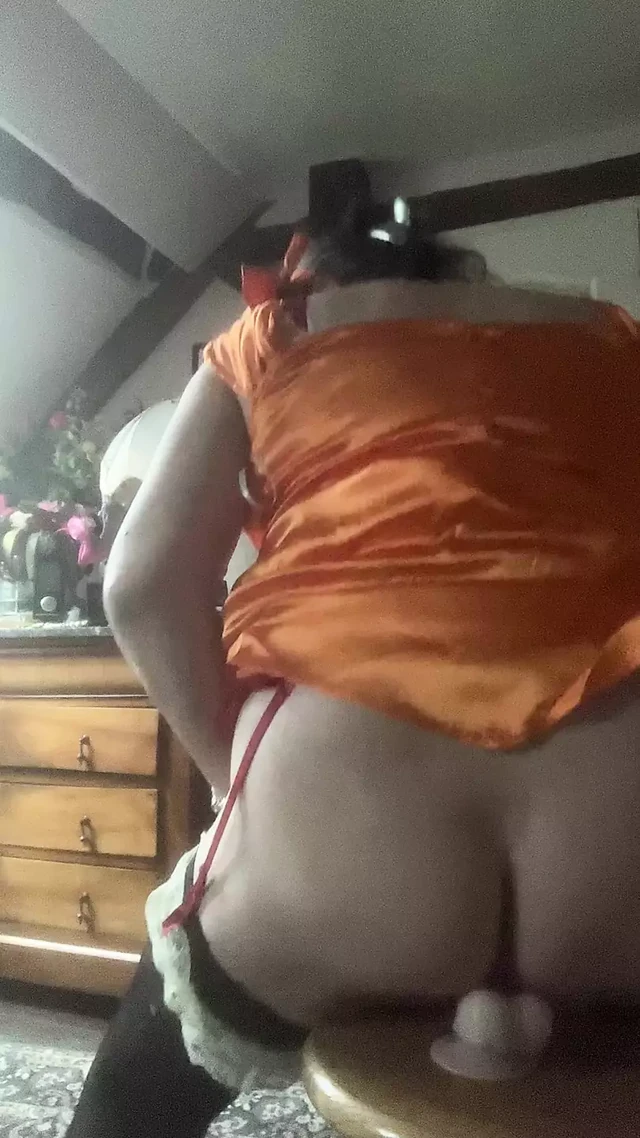 Dressed with an orange dress with a dildo