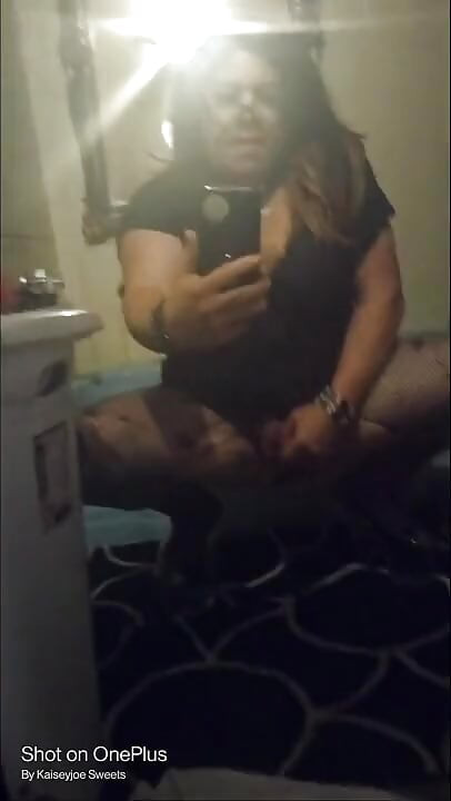 Sexy crossdresser Krissy Sweets in lingerie and high heels with fishnets.